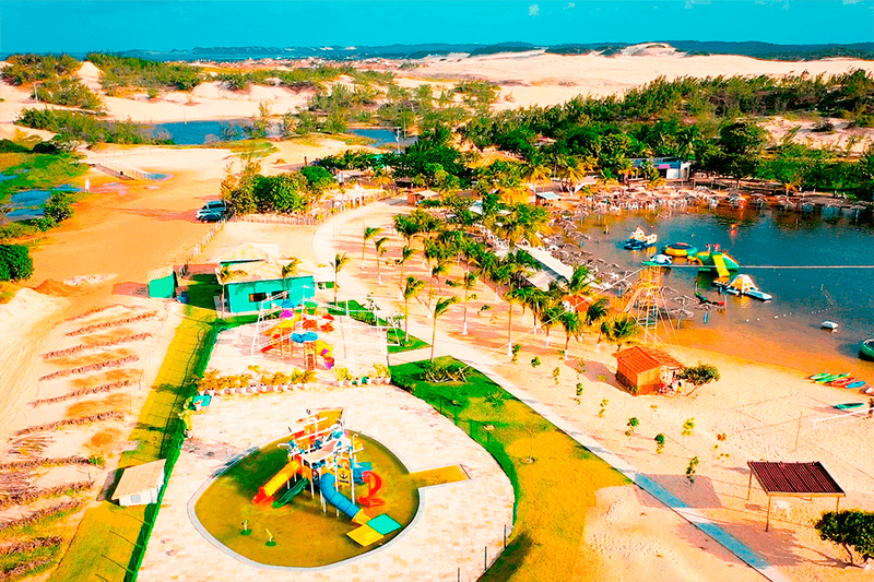 Lagoa de pitangui vista de cima, cercada por dunas e vegetação rasteira